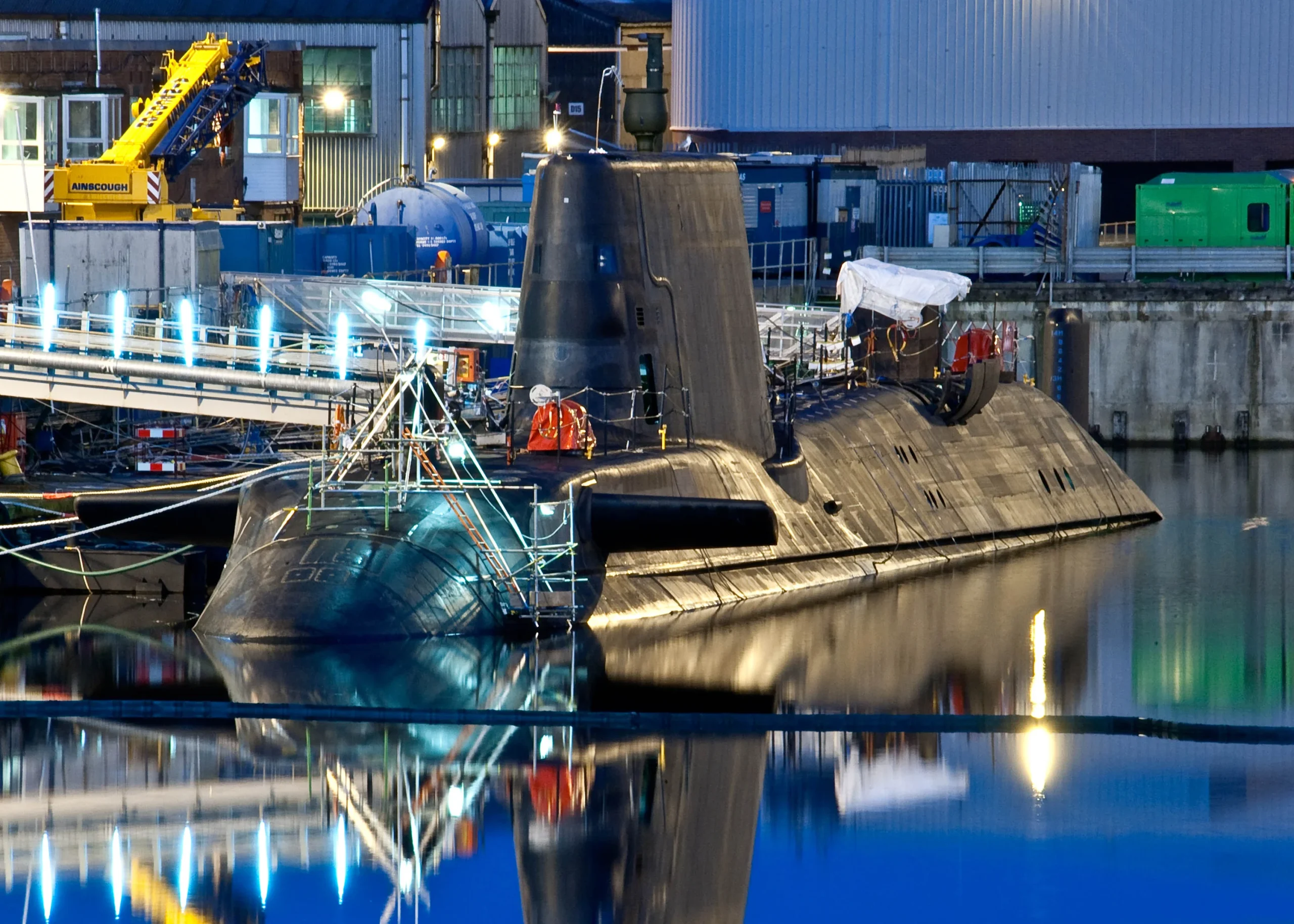Naval submarine in dock, being prepared for sea: Crew bustling, supplies loaded, systems checked. Ready to embark on a vital mission