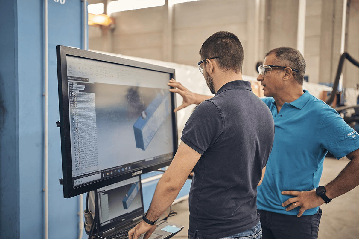 Two engineers talk over specifications of an IMI VIVO PEM electrolyser