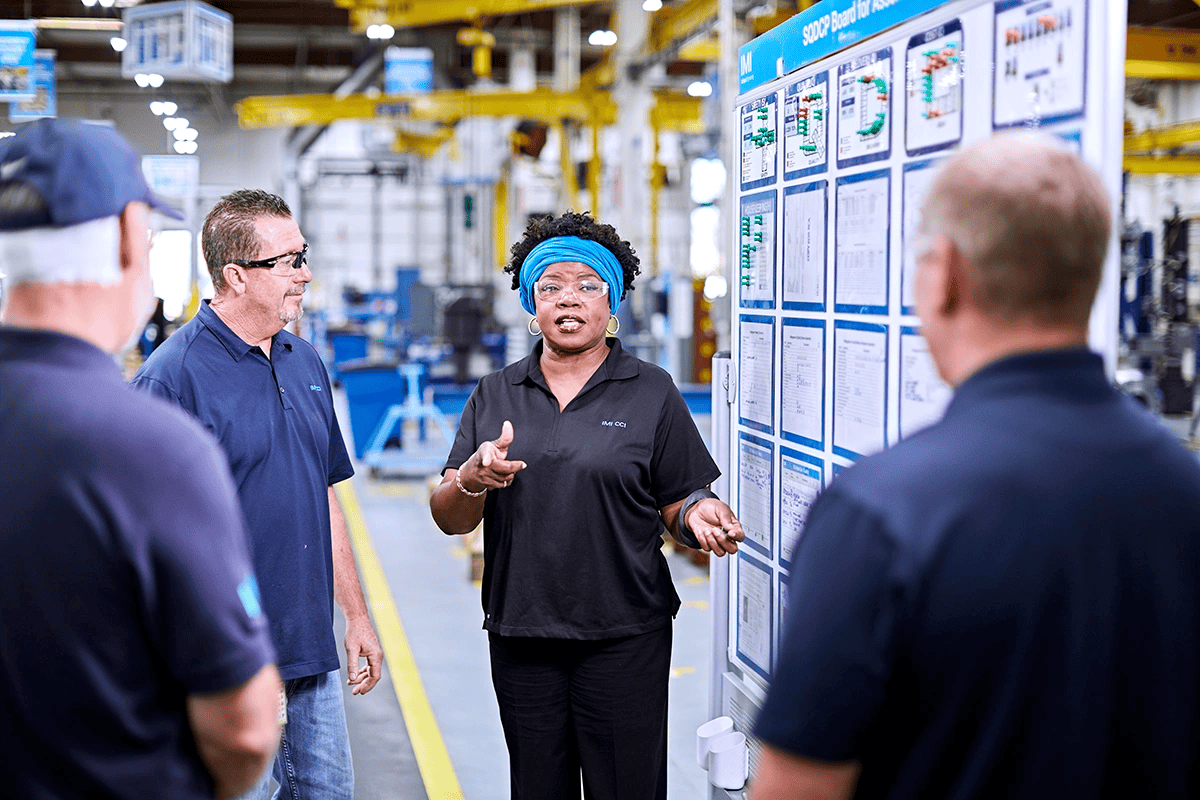 Engineers and shop specialists gather at an IMI CCI factory in the USA to collaboratively troubleshoot an urgent issue.