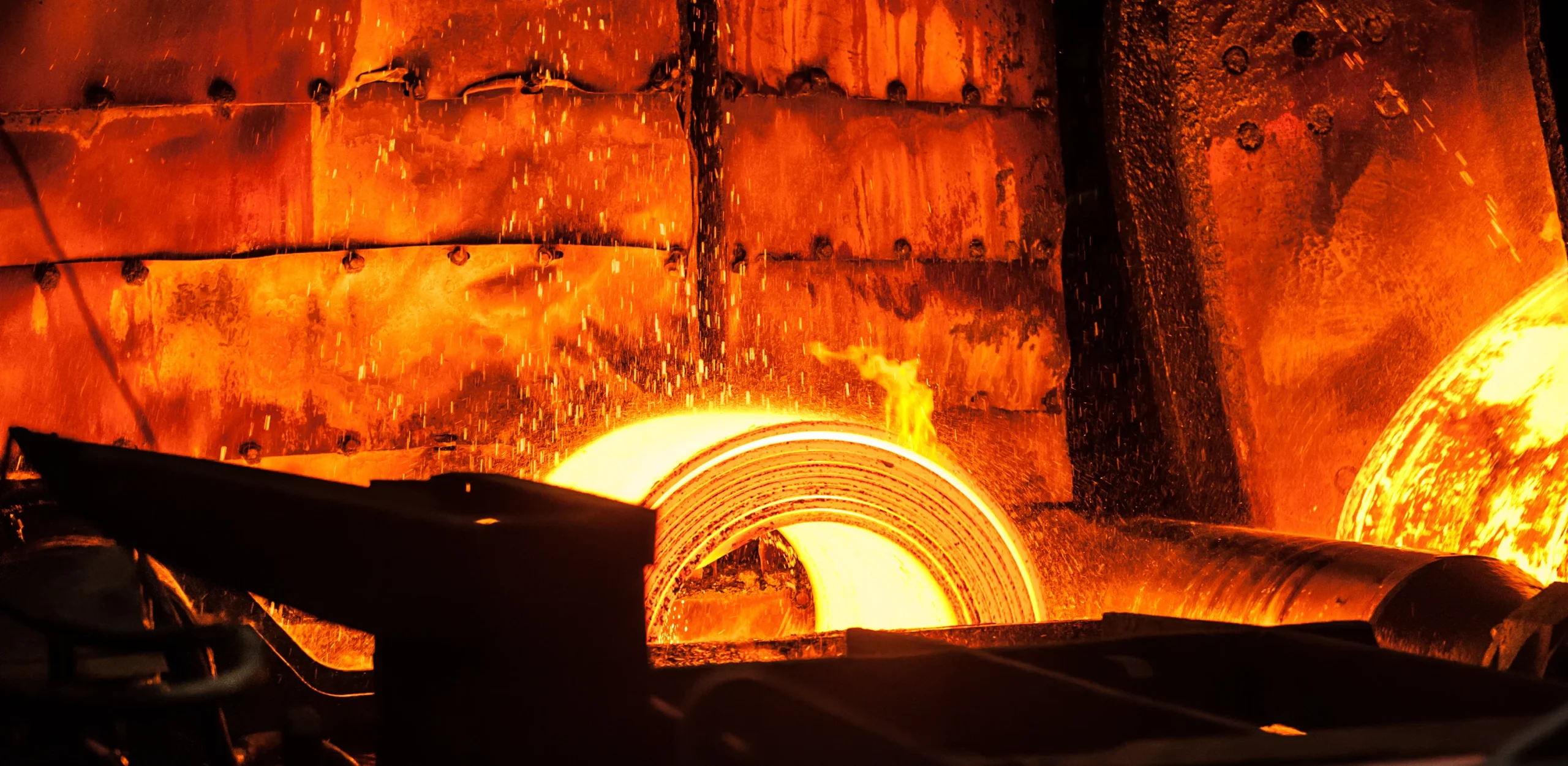 A fiery metal cylinder glides on a conveyor belt, radiating heat and power, propelling the manufacturing process forward.