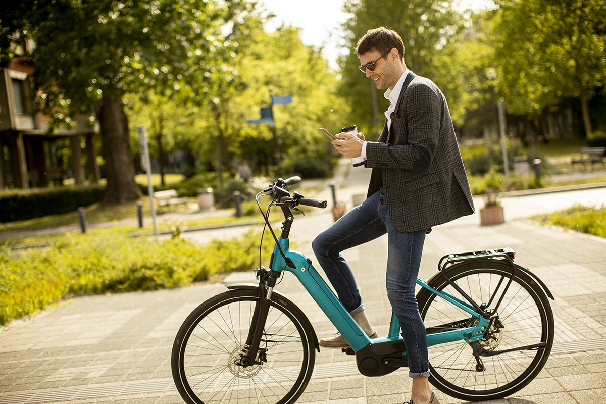 Man in park, sitting on electric bike experiencing the benefits of a green hydrogen future