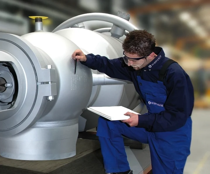 Focused man wearing safety gear inspects a safety valve at IMI Bopp & Reuther, a German industrial company.