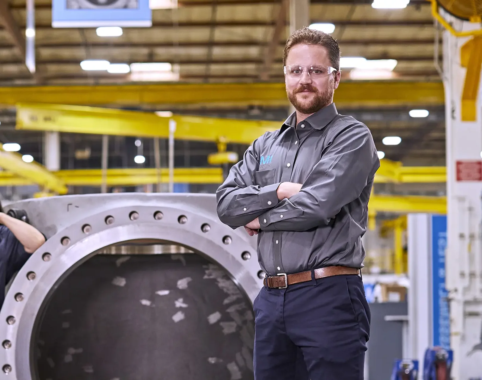 The Valve Doctor exudes confidence, ready to maintain and repair industrial components with expertise before a massive control valve.