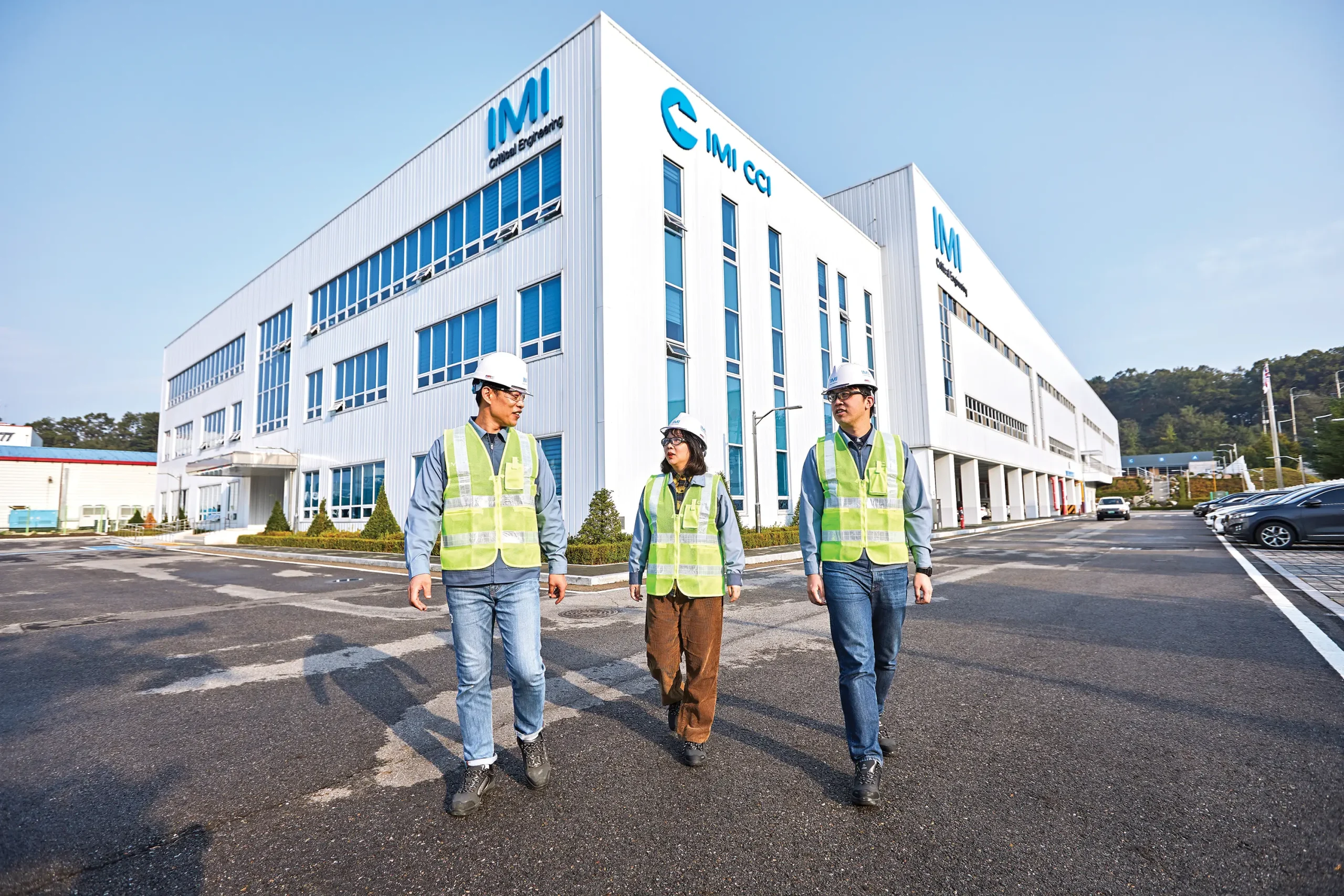 Engineers in safety gear outside IMI Korea, specialising in valve technologies, exemplify expertise and commitment.