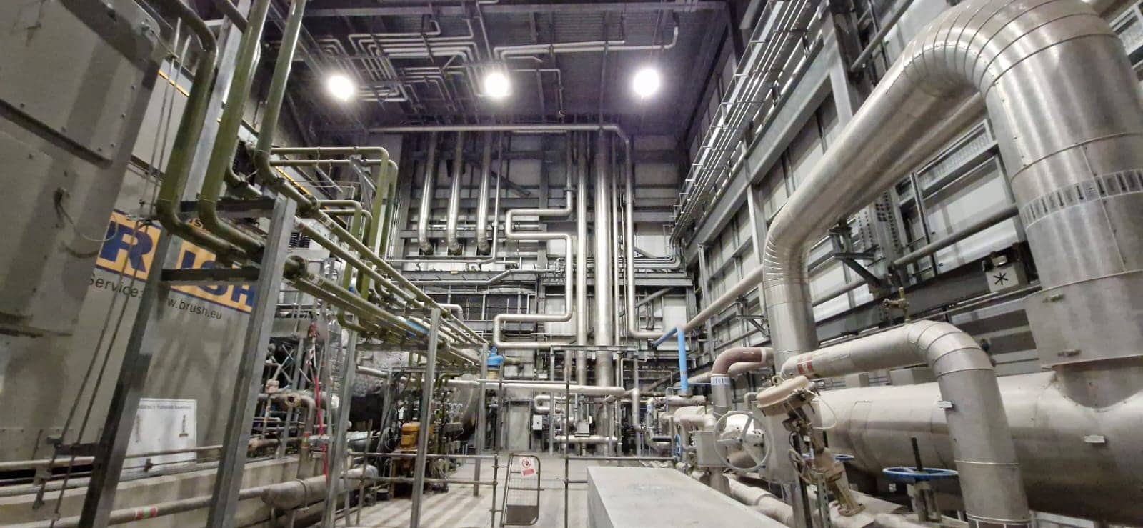 Interior of a waste-to-power facility with intricate piping, machinery, and advanced engineering for sustainable energy.