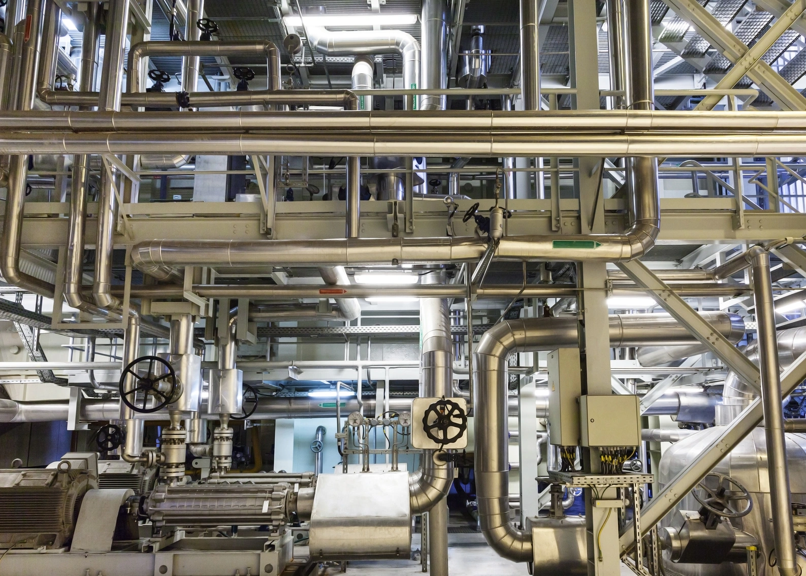 A well-lit power plant boiler room, with a network of pipes and machinery, exuding an industrial ambiance of power and energy.