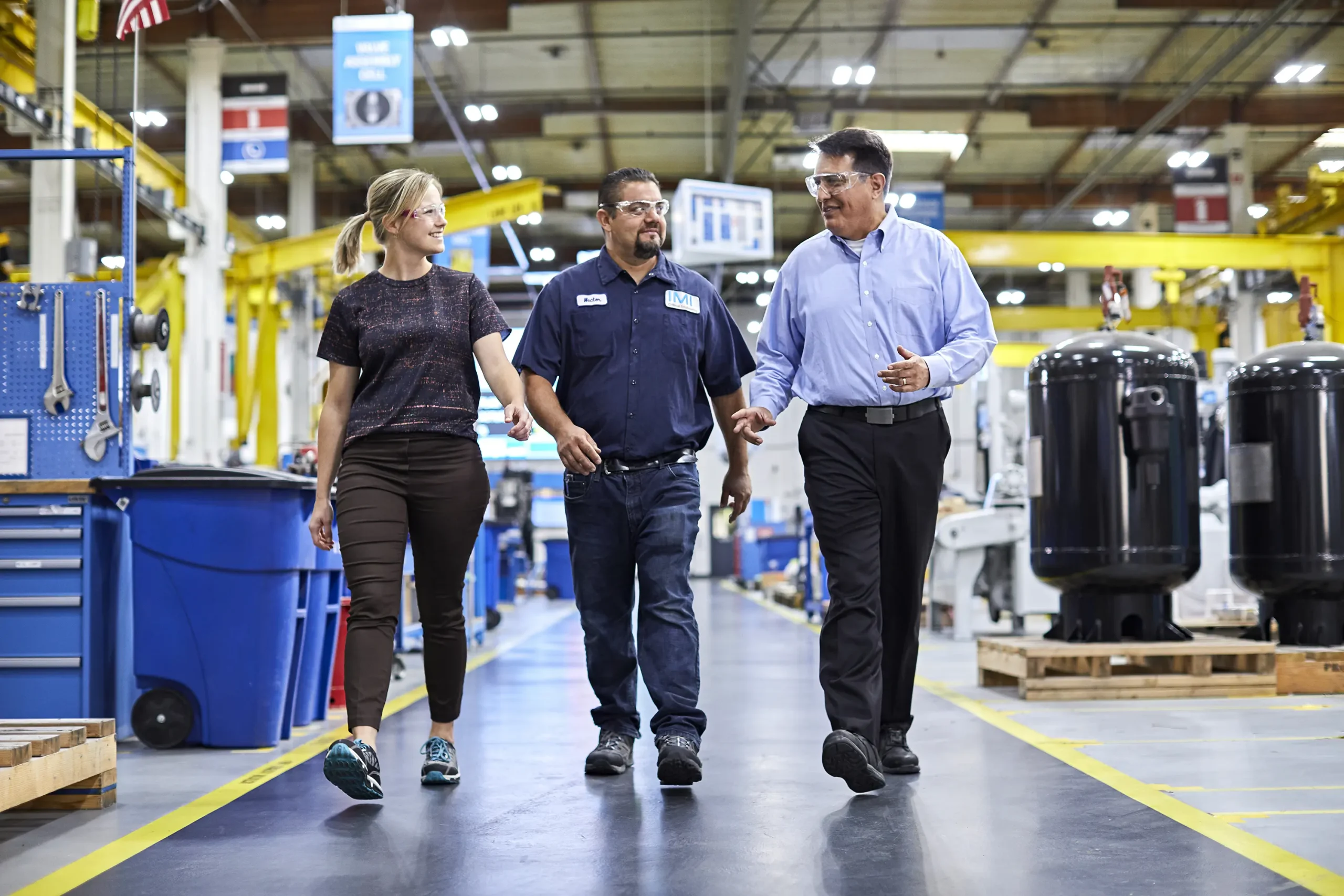Engineers walk through manufacturing hanger with control valves in shot