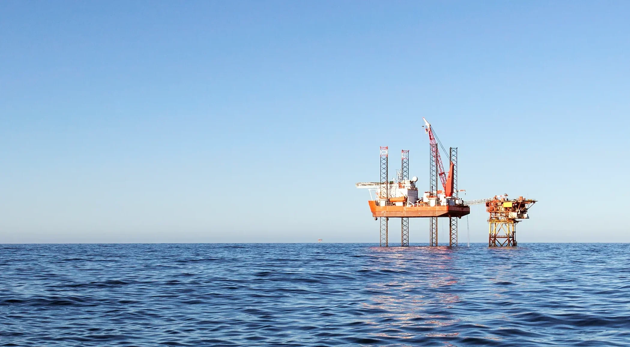 Offshore rig on the horizon, symbolising the oil and gas industry's vital role in energy production and economic growth