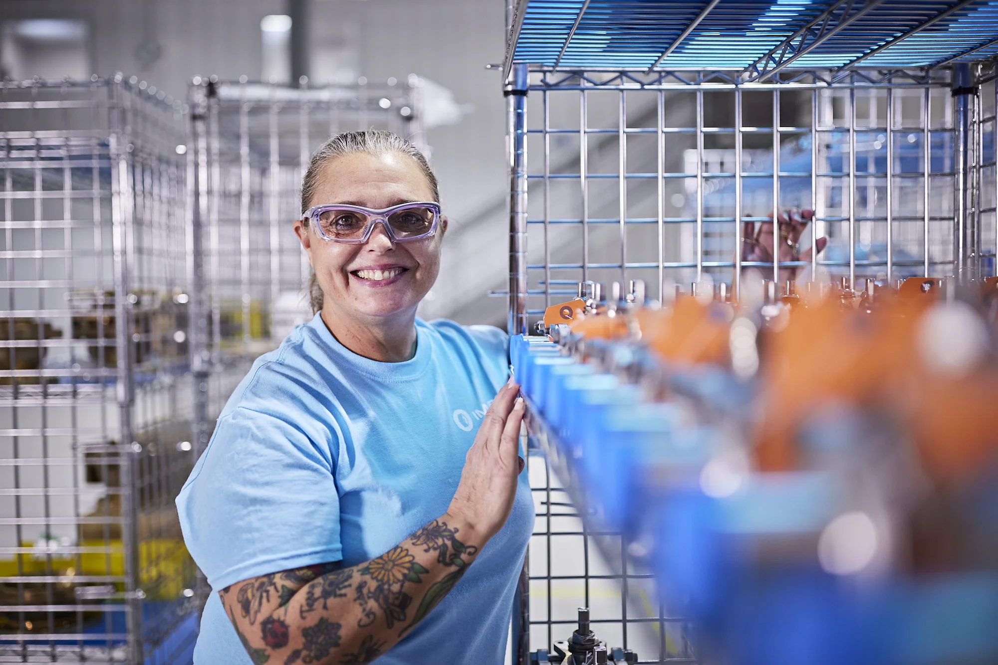 A knowledgeable woman confidently poses next to paint manufacturing valves, showcasing expertise and understanding of their vital role