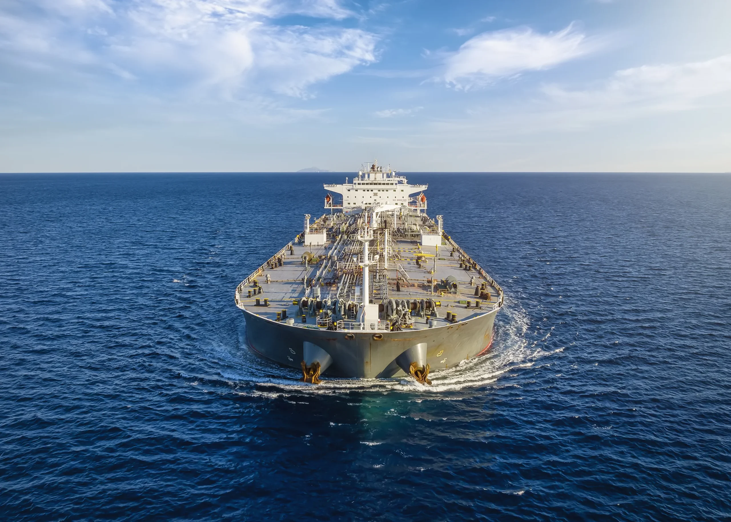 A cargo tanker sails on the blue sea, reliant on corrosion-resistant valves for safe and efficient marine operations