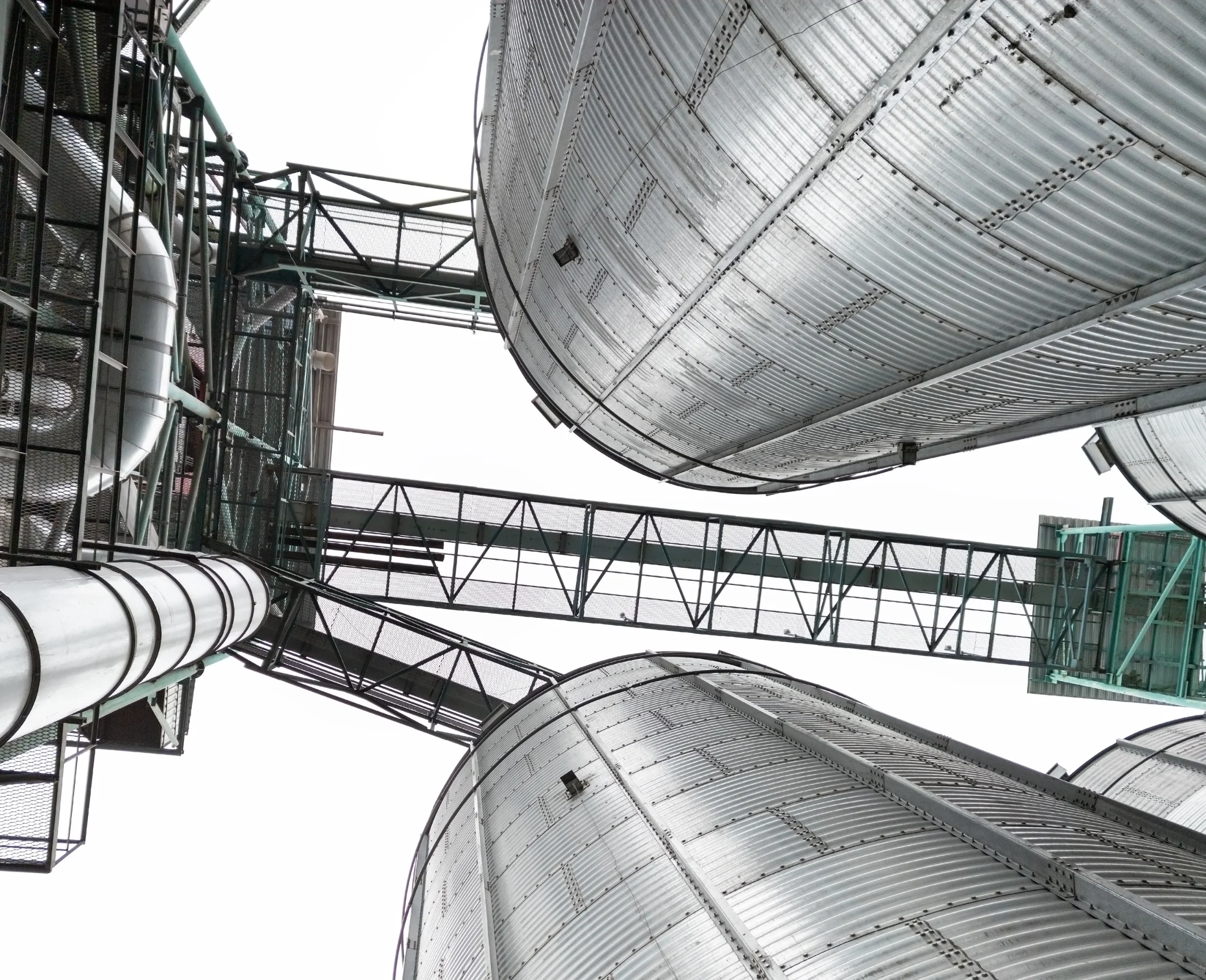 Rows of towering grain silos, standing tall against the sky, storing abundant harvests of corn, wheat, and barley for ethanol production