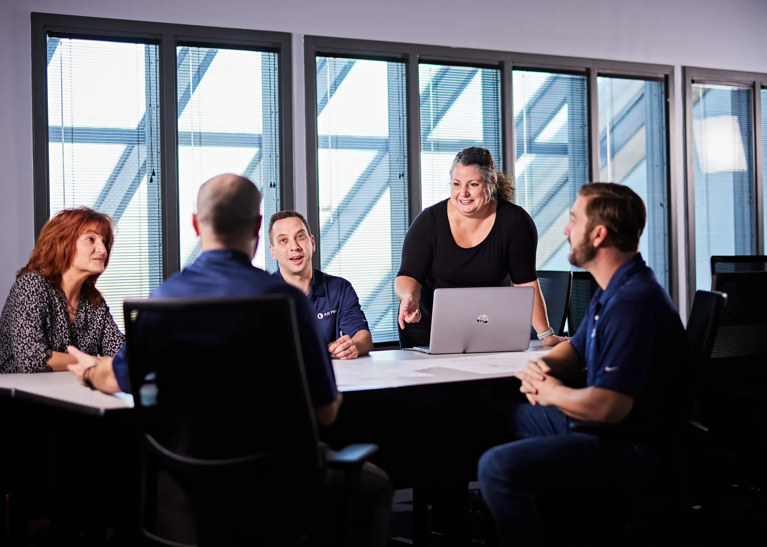 Engineers in IMI's Growth Hub program gather in a vibrant meeting, exchanging ideas for new innovations and fostering collaboration.