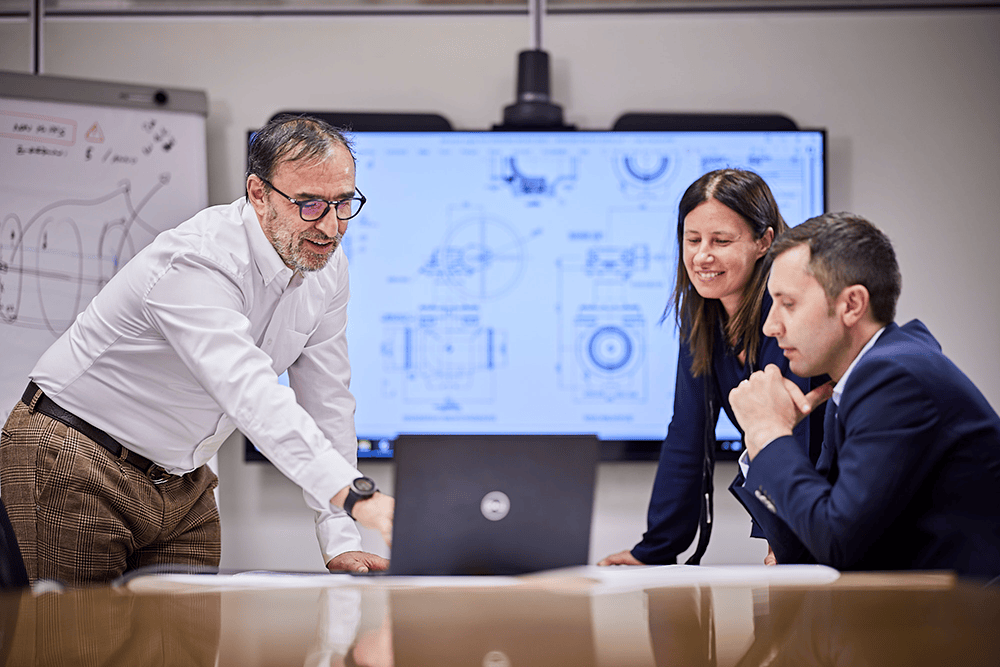 Engineer explains technical valve details while standing in front of bespoke product drawings.